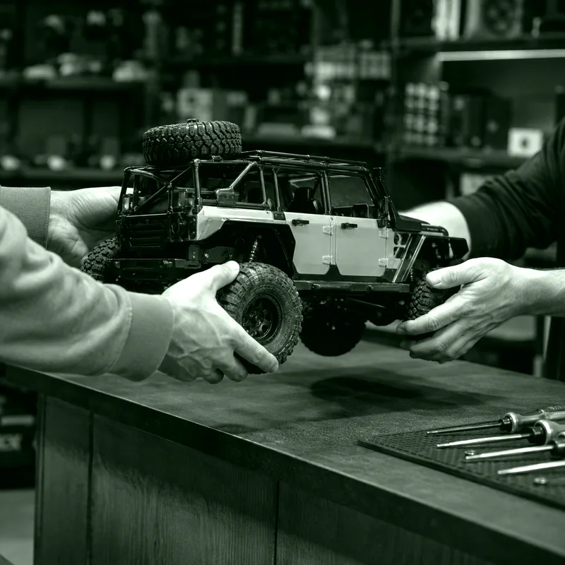 Dos personas entregando un auto RC para servicio técnico